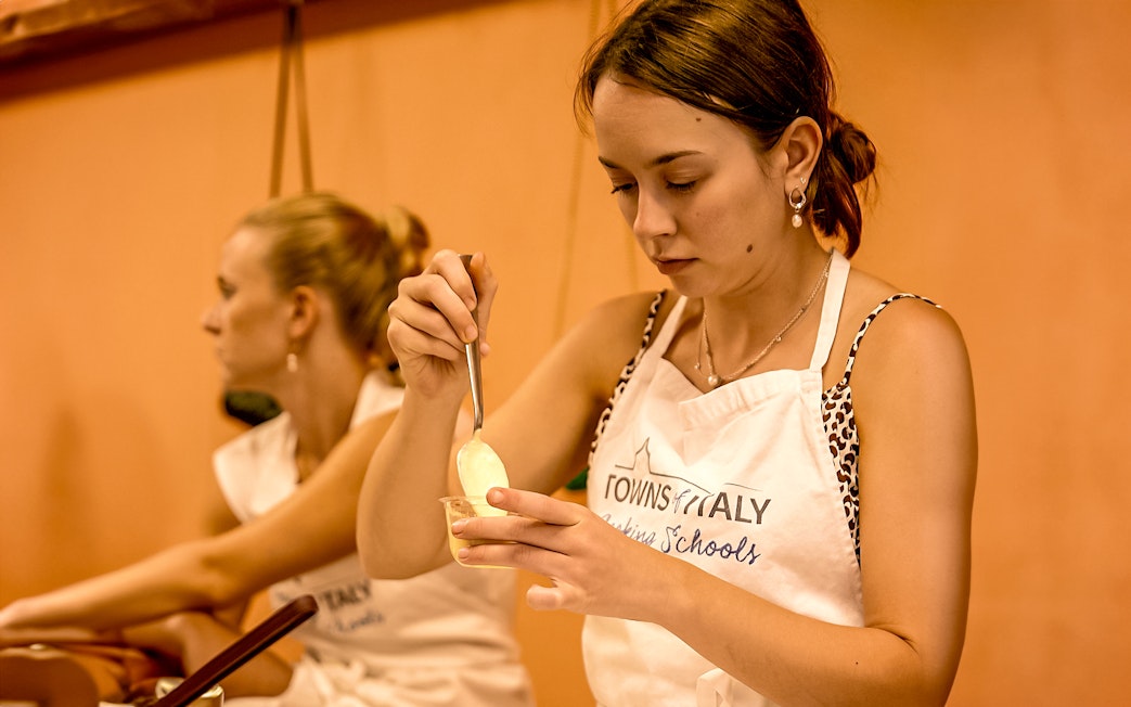 Florence cooking class participant preparing a dish with a spoon.