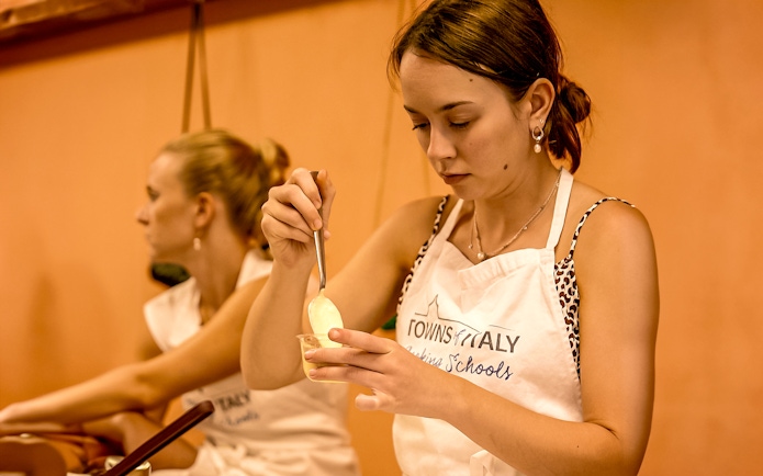 Florence cooking class participant preparing a dish with a spoon.