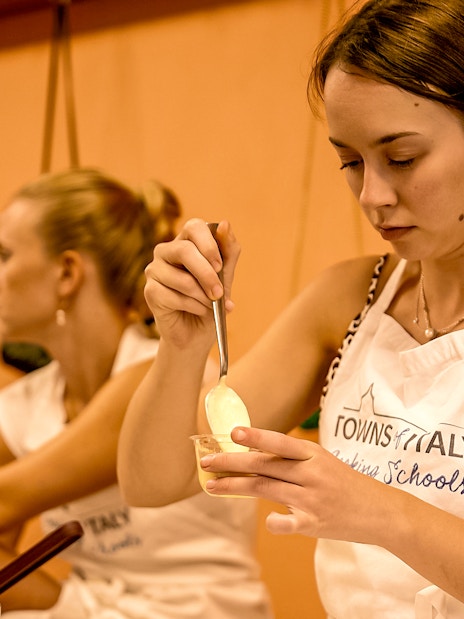 Florence cooking class participant preparing a dish with a spoon.