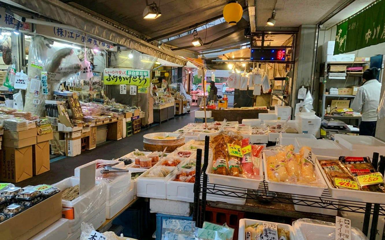 Tsukiji Fish Market interior with seafood and packaged goods on display.