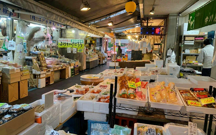 Tsukiji Fish Market interior with seafood and packaged goods on display.