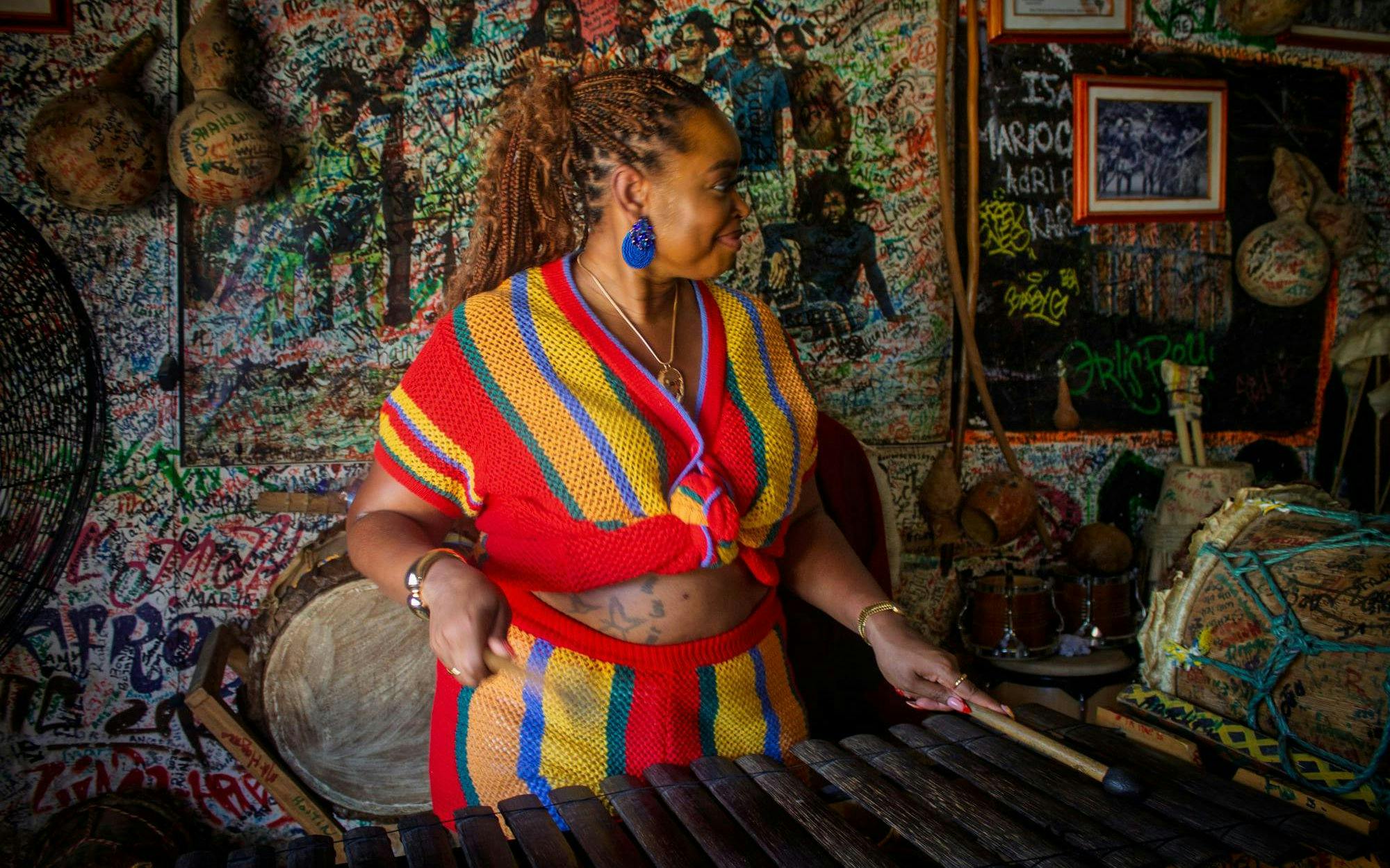 Palenquera woman playing traditional music in a vibrant cultural center.