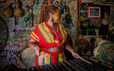 Palenquera woman playing traditional music in a vibrant cultural center.