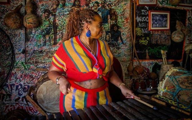 Palenquera woman playing traditional music in a vibrant cultural center.