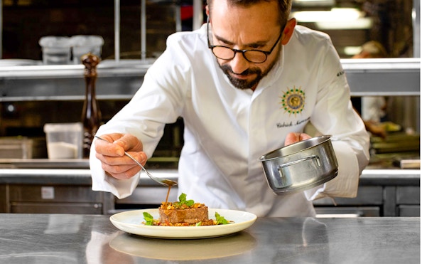 Chef preparing gourmet dish for Seine River lunch cruise on Bateaux Parisiens.