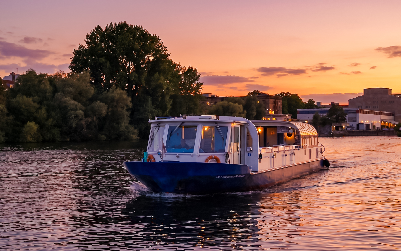 Dinner cruise boat on Berlin's Spree River at sunset.