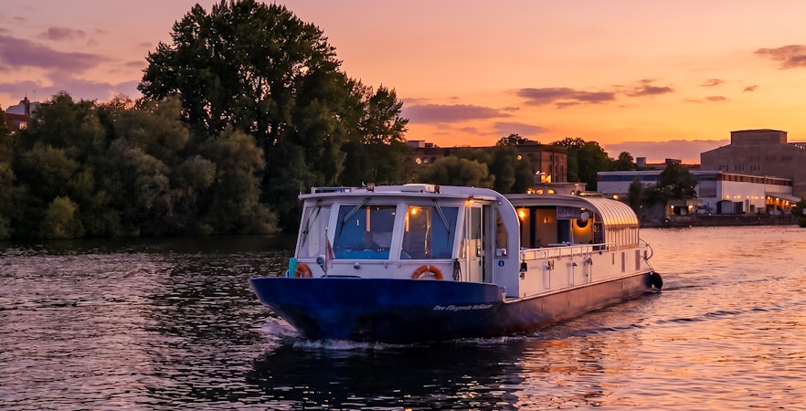 Dinner cruise boat on Berlin's Spree River at sunset.