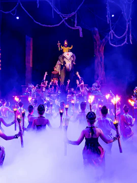 Performers with torches surround an elephant and rider on stage at Phuket Fantasea show.