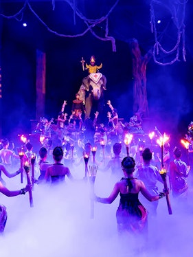 Performers with torches surround an elephant and rider on stage at Phuket Fantasea show.