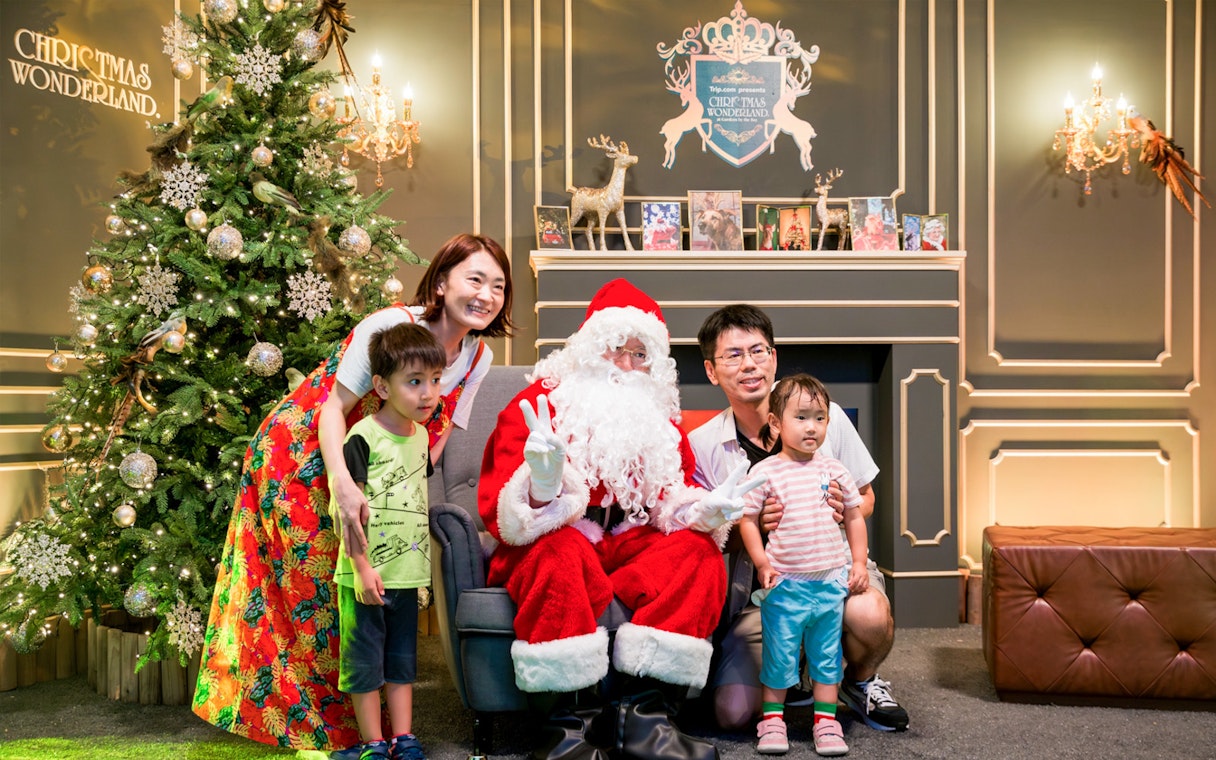 Family posing with Santa at Christmas Wonderland, near decorated tree, GBB Cloud Forest & SuperTree.