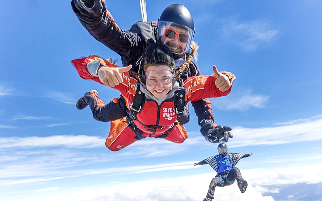 Tandem skydive over Wanaka with clear blue skies and scenic views.