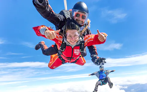 Tandem skydive over Wanaka with clear blue skies and scenic views.