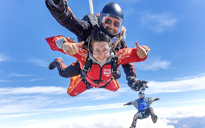 Tandem skydive over Wanaka with clear blue skies and scenic views.