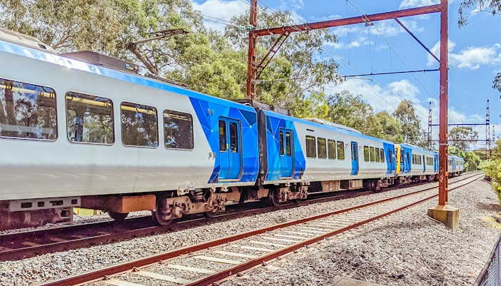 Train traveling through lush greenery near Melbourne Skydeck.