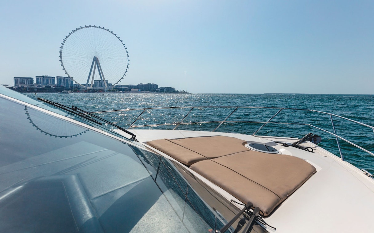 Viktoriia Luxury Yacht with Dubai Ferris wheel in the background on the water.
