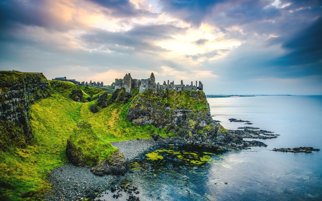 Dunluce Castle ruins on a cliff overlooking the sea in Northern Ireland.