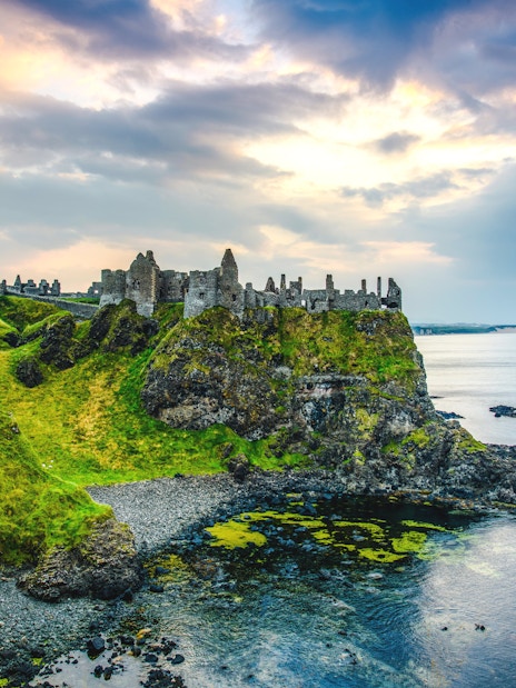 Dunluce Castle ruins on a cliff overlooking the sea in Northern Ireland.