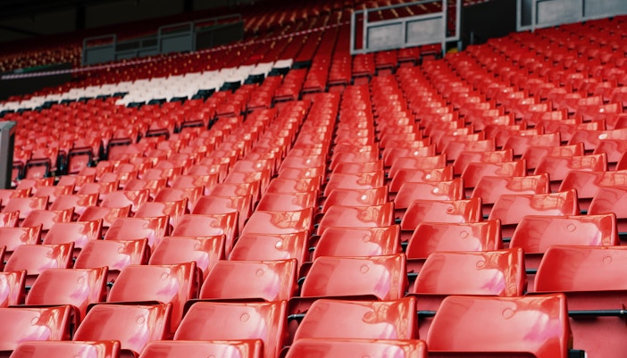 Bright red stadium seats at Anfield Stadium, Liverpool.
