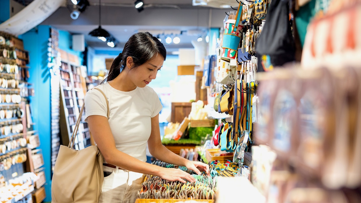 Woman browsing souvenirs in a shop.