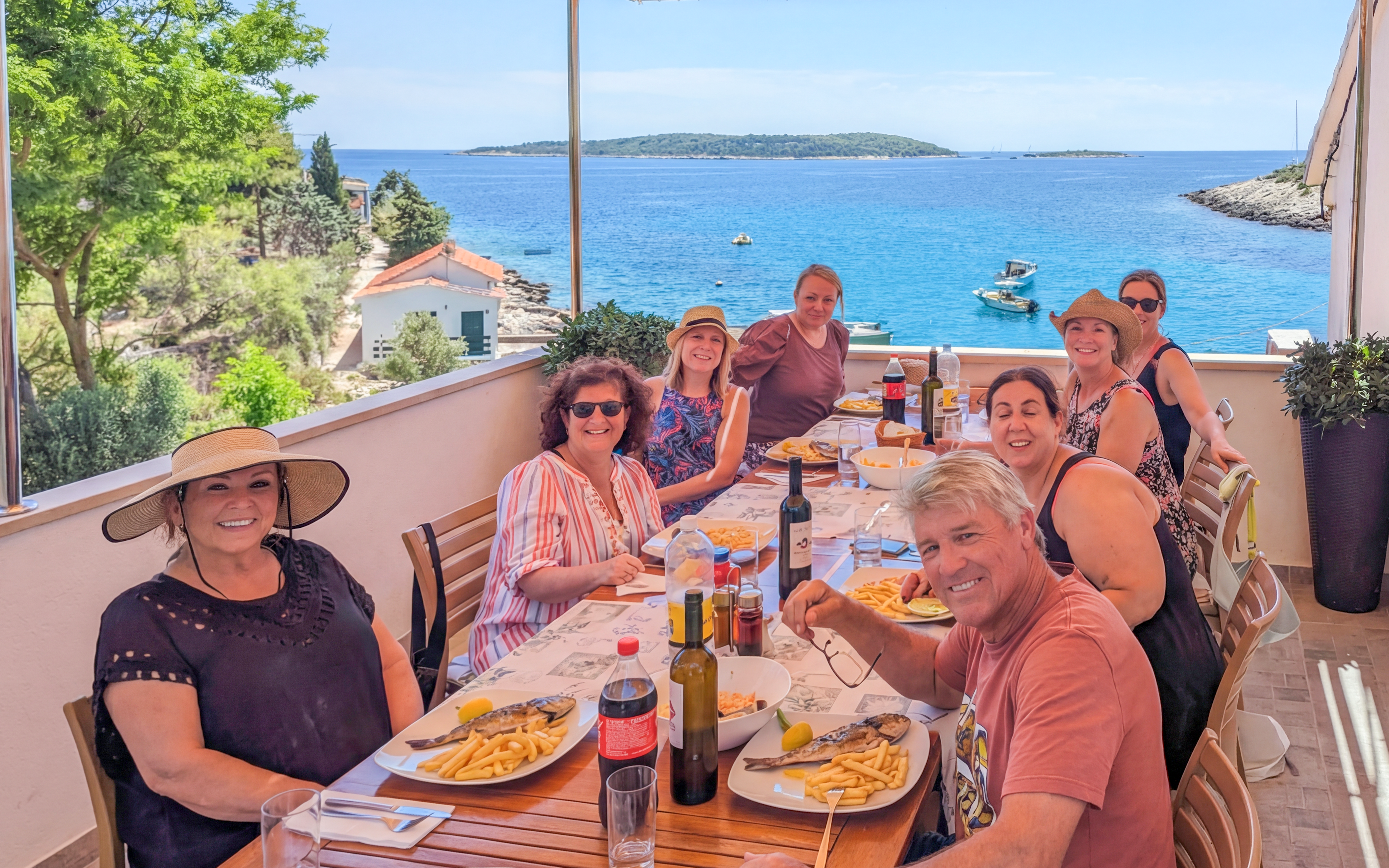 Group dining on terrace with sea view during Blue Cave and Blue Lagoon boat tour.