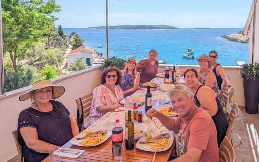 Group dining on terrace with sea view during Blue Cave and Blue Lagoon boat tour.