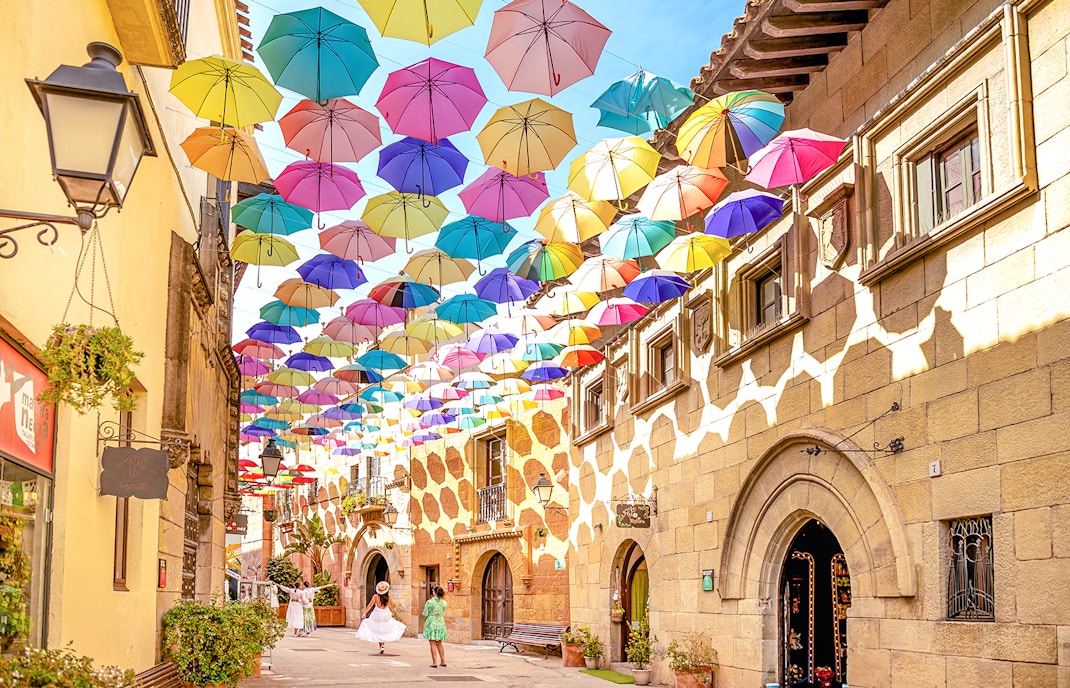 Tourists exploring Poble Espanyol in Barcelona with Skip-the-Line Tickets, admiring the unique architecture and vibrant streets