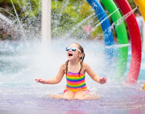 kids having fun under fountain in children's area in Aqualand