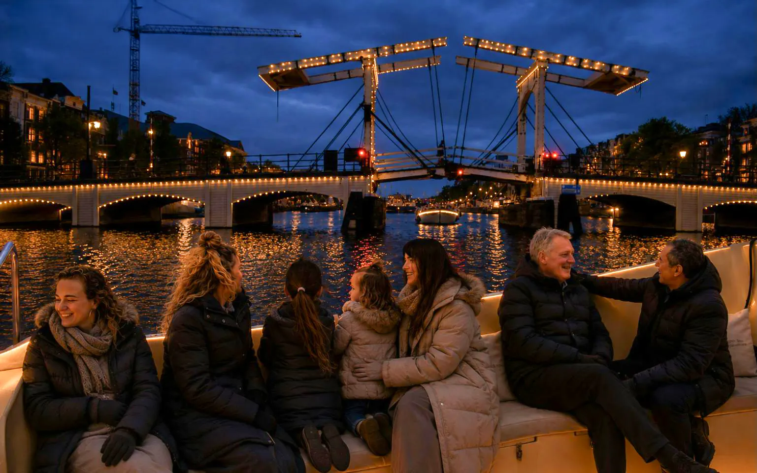 People enjoying a boat tour during the Amsterdam Light Festival with illuminated bridge in view.