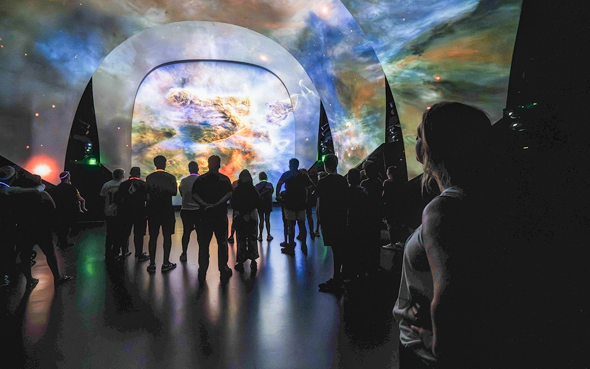Visitors viewing a cosmic display at Kennedy Under the Stars, exclusive after-hours event.