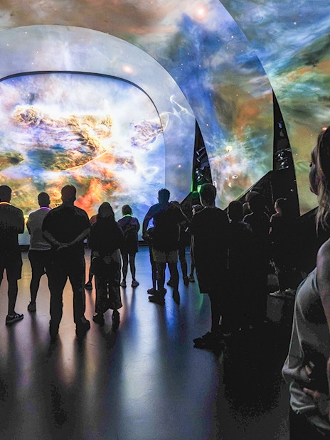 Visitors viewing a cosmic display at Kennedy Under the Stars, exclusive after-hours event.