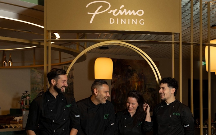 Staff at Plaza Premium First lounge, Terminal 1, Fiumicino Airport, Rome, under Primo Dining sign.