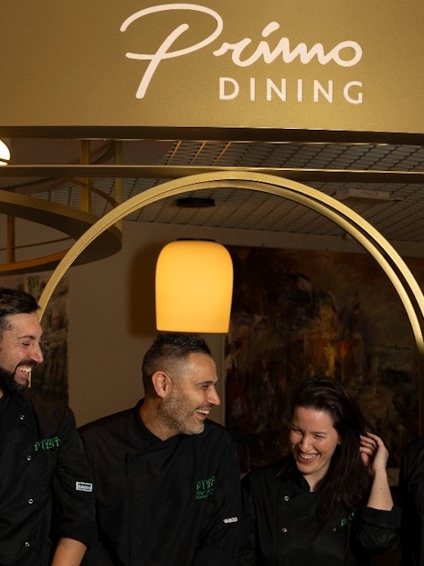 Staff at Plaza Premium First lounge, Terminal 1, Fiumicino Airport, Rome, under Primo Dining sign.