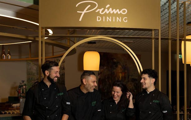 Staff at Plaza Premium First lounge, Terminal 1, Fiumicino Airport, Rome, under Primo Dining sign.