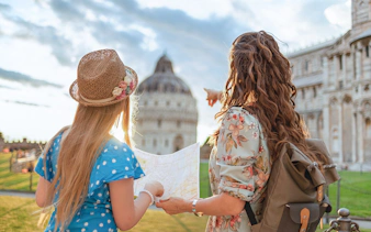 Tour guide explaining Pisa Baptistery to a girl holding a map in Pisa, Italy.