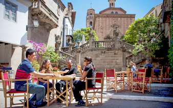 Visitors enjoying a meal at an outdoor cafe in Poble Espanyol, Barcelona.