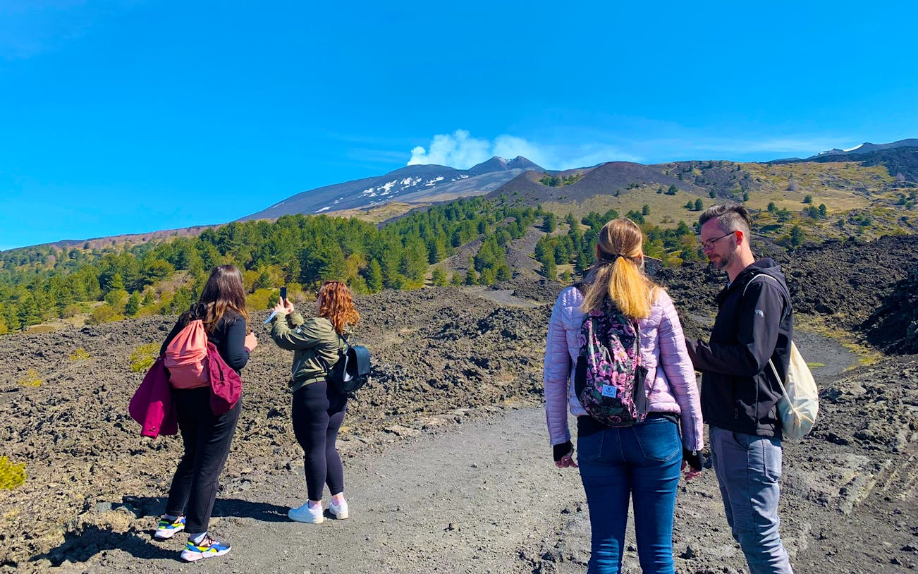 Tourists exploring volcanic landscape at Etna Park during a full-day jeep tour.