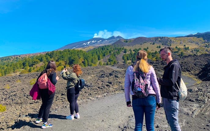 Tourists exploring volcanic landscape at Etna Park during a full-day jeep tour.