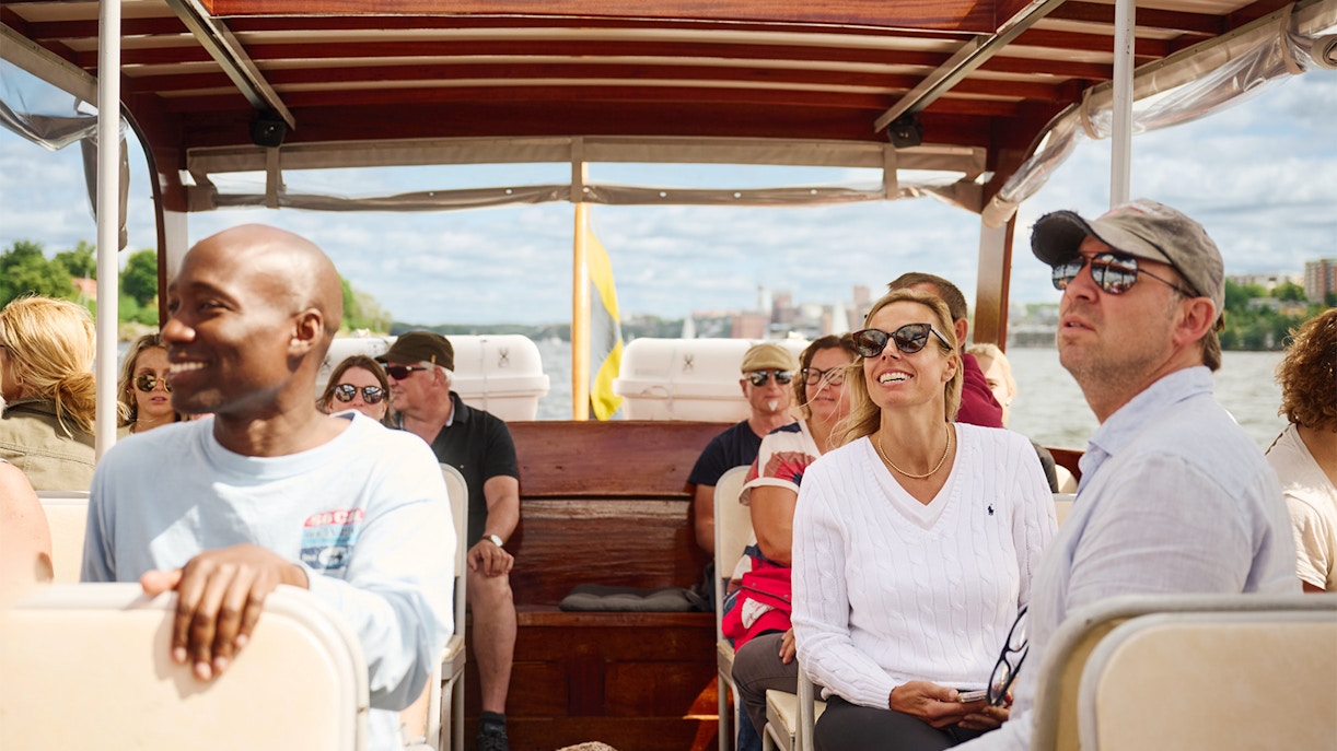 People enjoying a ride on a classic wooden boat in the Stockholm Archipelago.