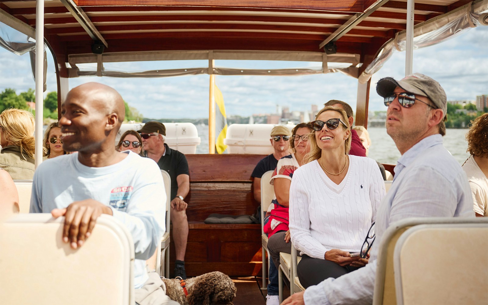 People enjoying a ride on a classic wooden boat in the Stockholm Archipelago.