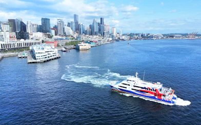 High-speed ferry on Puget Sound with Seattle skyline in the background.