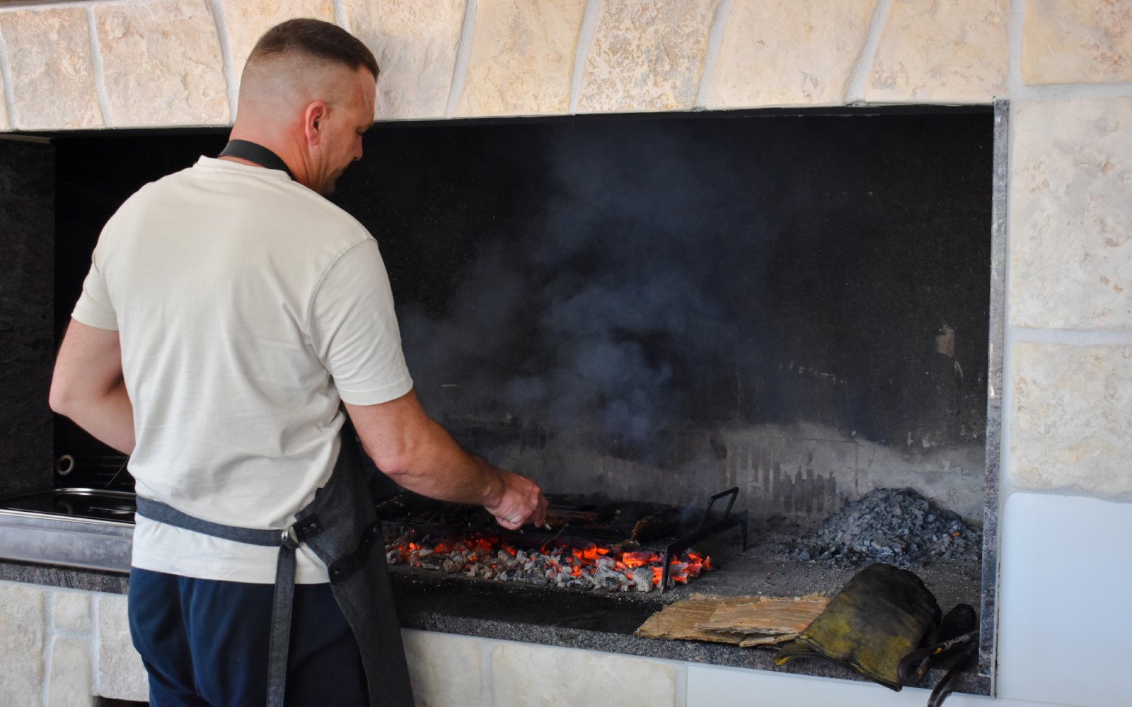 Man grilling food over open flames during Blue Lagoon and 3 Island tour from Split.