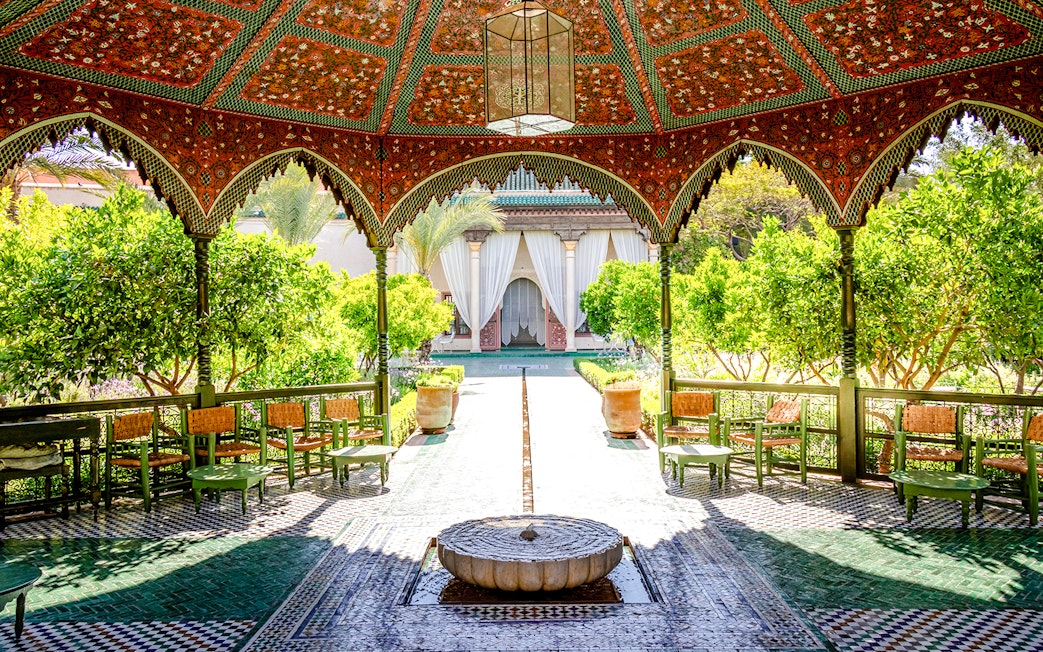 Jardin Secret courtyard with ornate pavilion and lush greenery in Marrakech, Morocco.