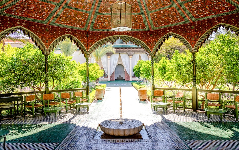 Jardin Secret courtyard with ornate pavilion and lush greenery in Marrakech, Morocco.