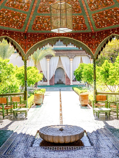 Jardin Secret courtyard with ornate pavilion and lush greenery in Marrakech, Morocco.