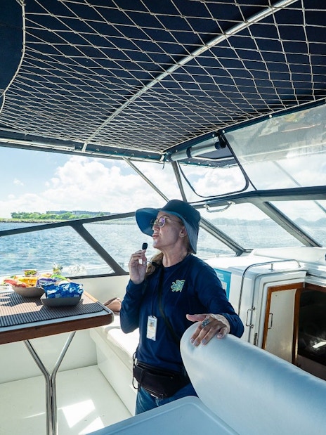 Boat guide explaining sightseeing spots to tourists during Rio boat tour.