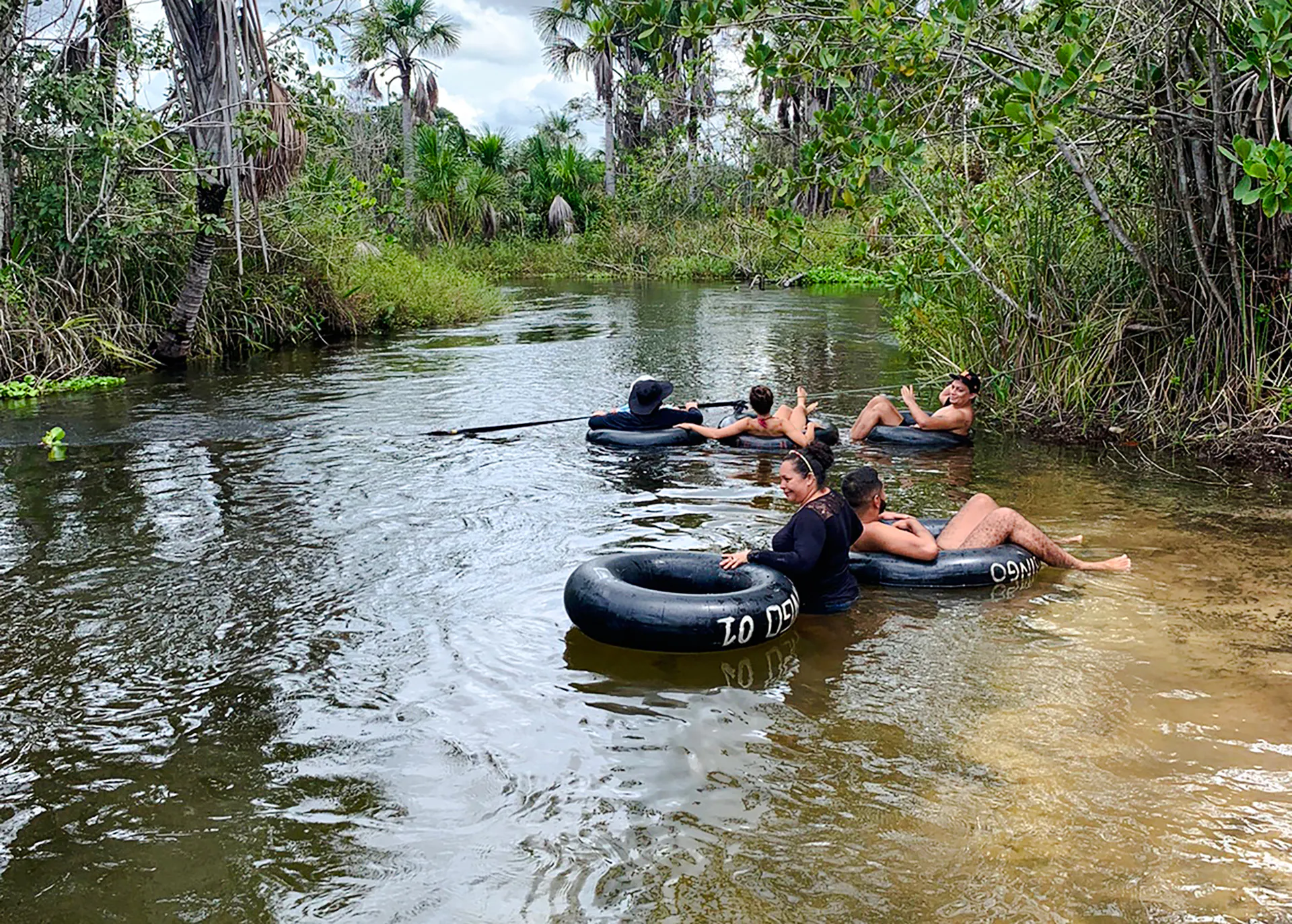 Tubing in Cardosa river, Barreirinhas with group enjoying the water surrounded by lush greenery.