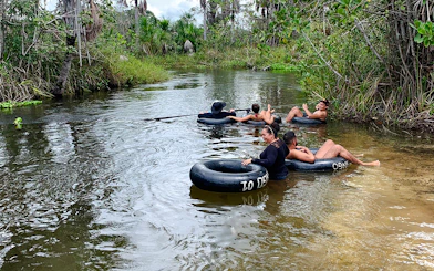 Tubing in Cardosa river, Barreirinhas with group enjoying the water surrounded by lush greenery.