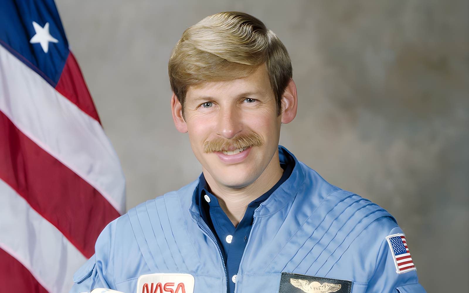 Astronaut Woody Spring in space suit with Earth in the background.