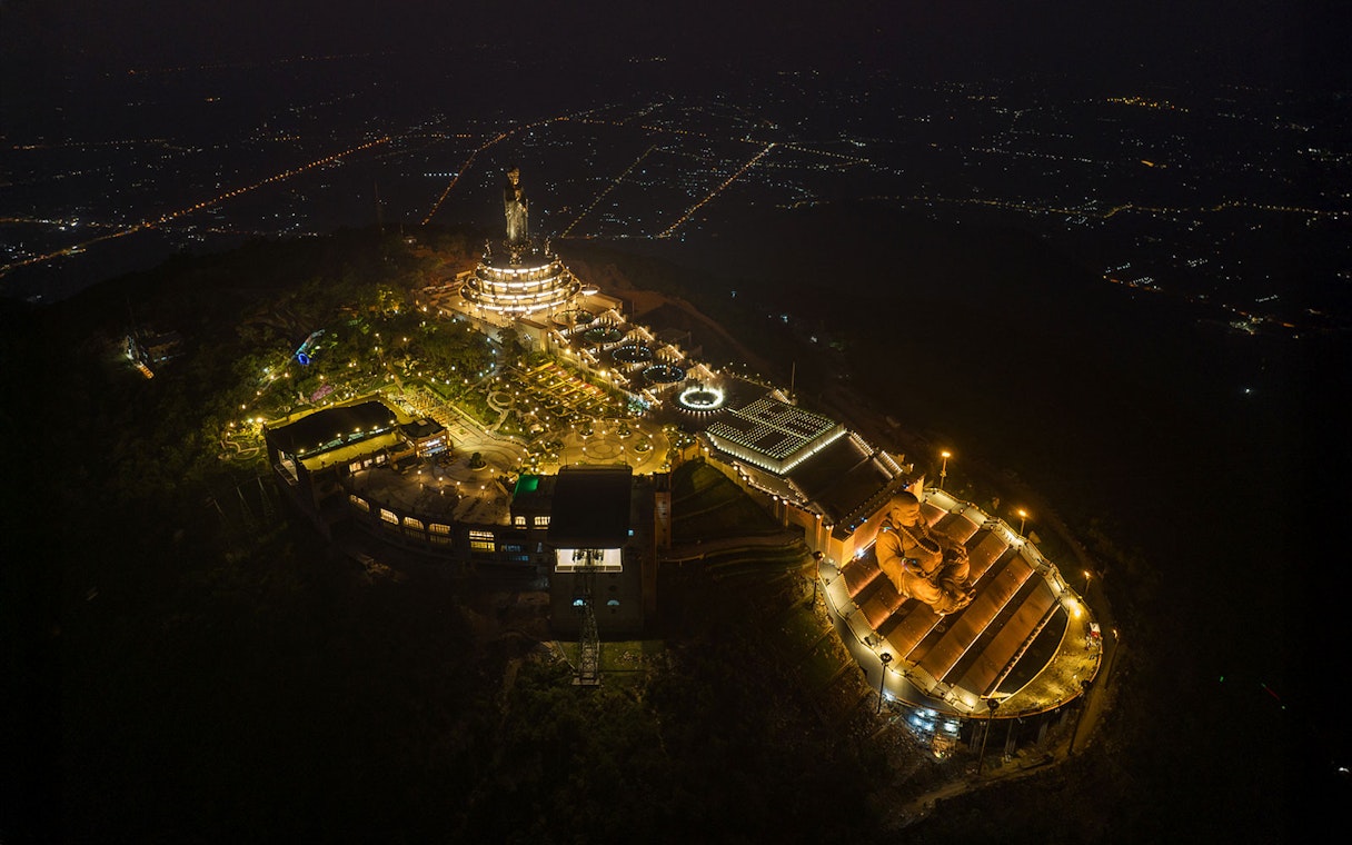Aerial view of Van Son Peak at night with illuminated Sun World Ba Den Mountain complex.