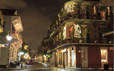 New Orleans street at night with festive lights and historic architecture.